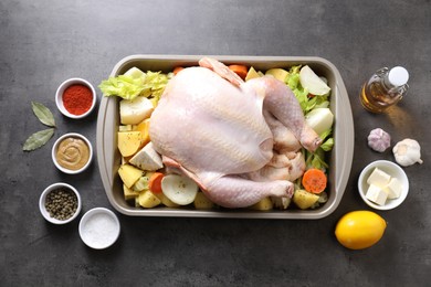 Photo of Raw turkey with different vegetables and spices on grey table, flat lay