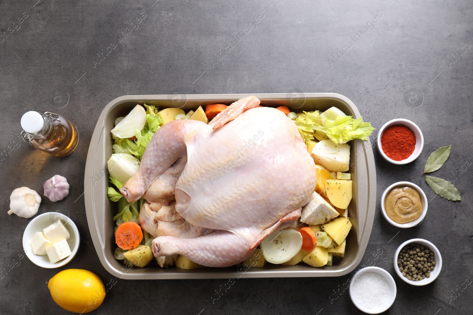 Photo of Raw turkey with different vegetables and spices on grey table, flat lay. Space for text