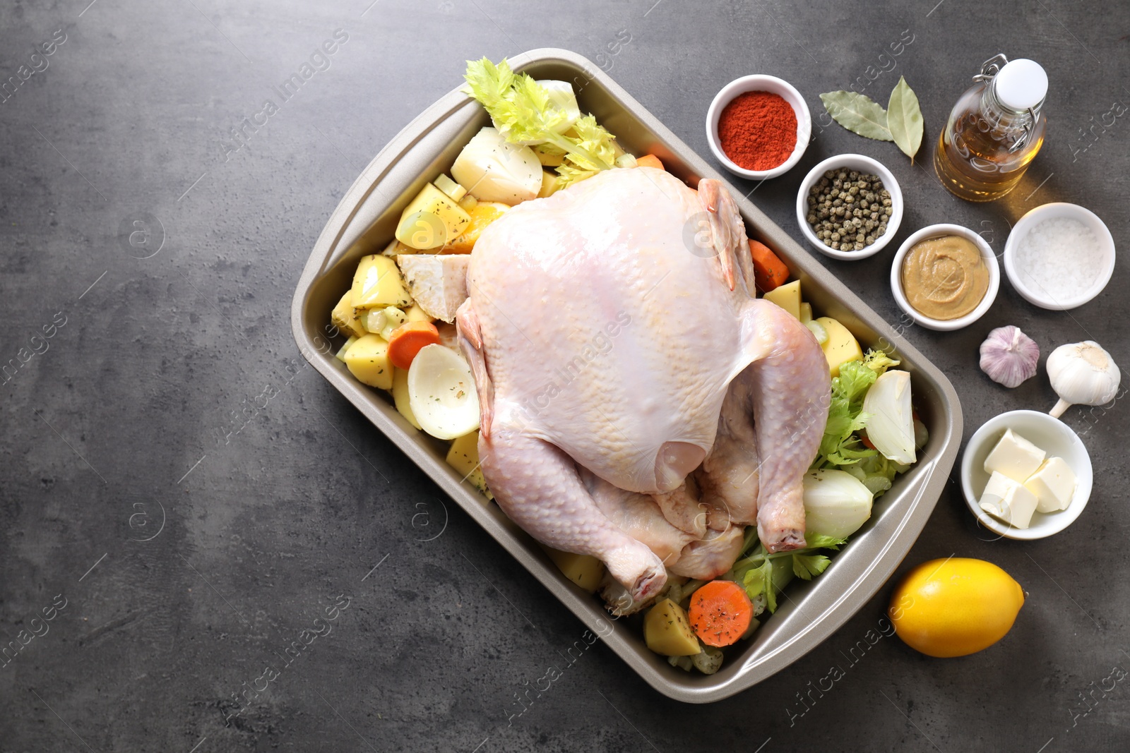 Photo of Raw turkey with different vegetables and spices on grey table, flat lay. Space for text