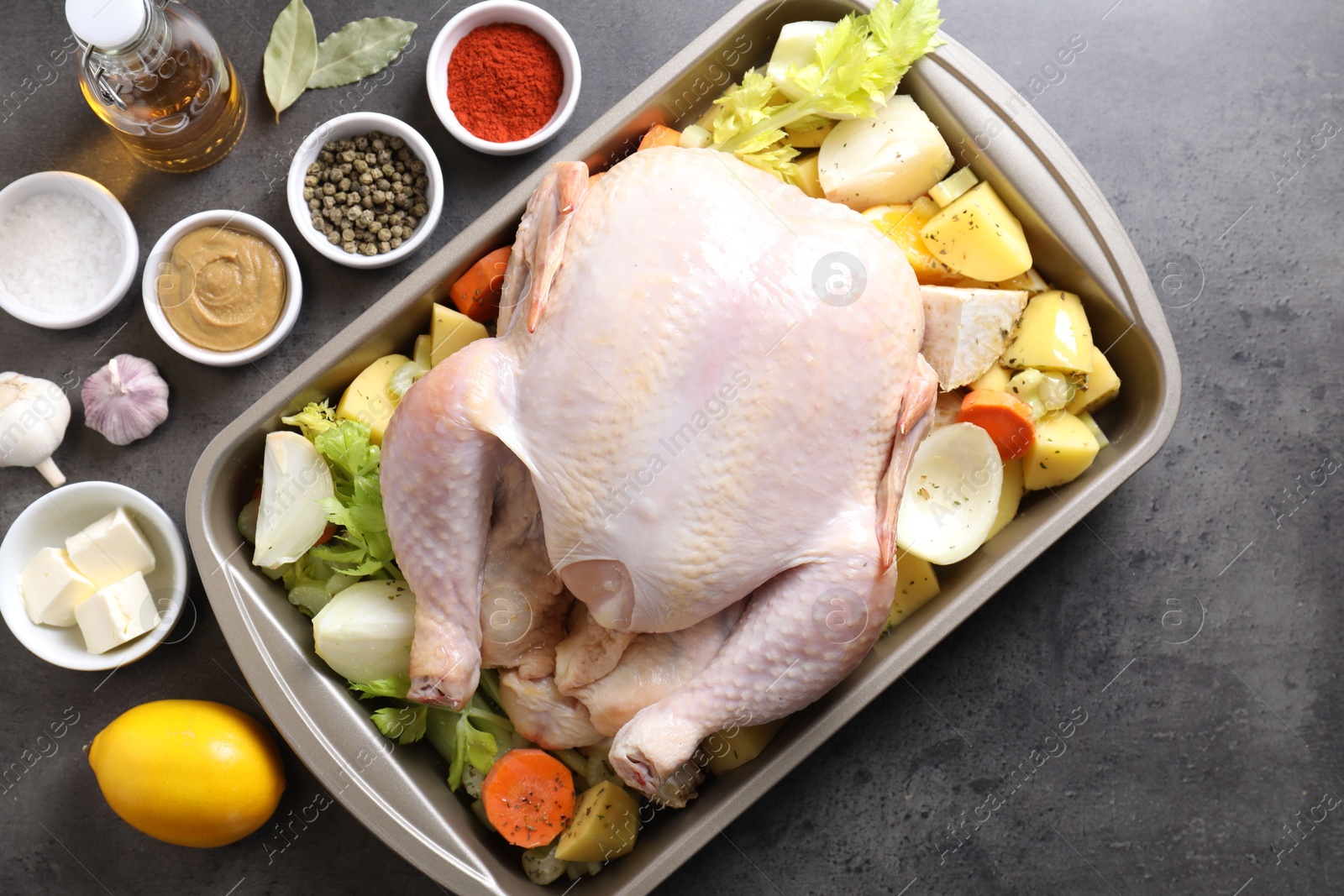 Photo of Raw turkey with different vegetables and spices on grey table, flat lay