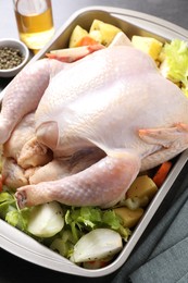 Photo of Raw turkey with different vegetables and spices on grey table, closeup