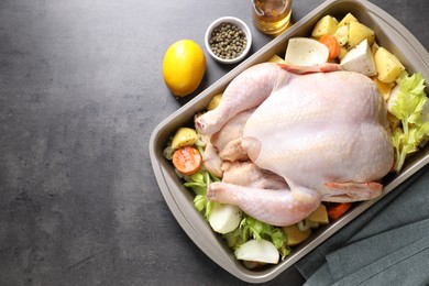 Photo of Raw turkey with different vegetables and spices on grey table, above view. Space for text