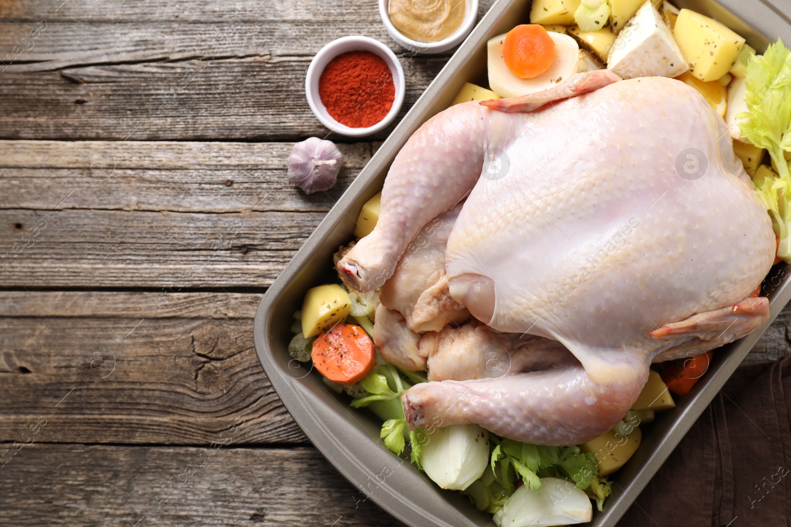 Photo of Raw turkey with different vegetables and spices on wooden table, top view. Space for text