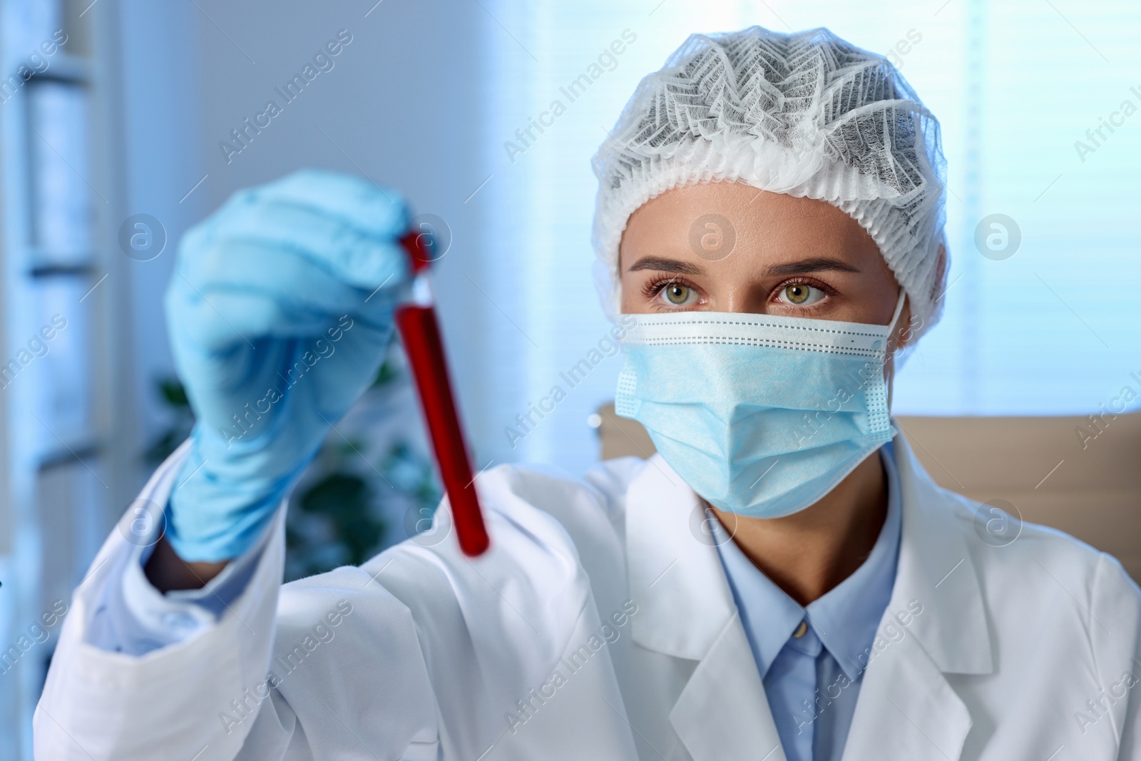 Photo of Laboratory testing. Doctor holding test tube with blood sample indoors