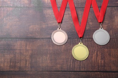 Photo of Golden, silver and bronze medals on wooden background, top view. Space for text