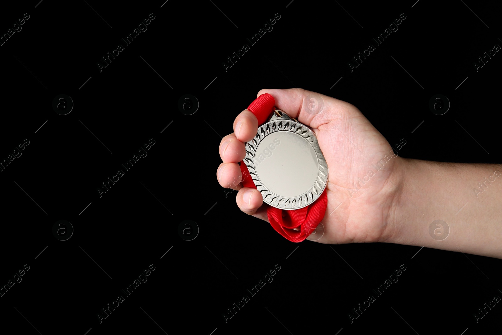 Photo of Man with silver medal on black background, closeup. Space for text