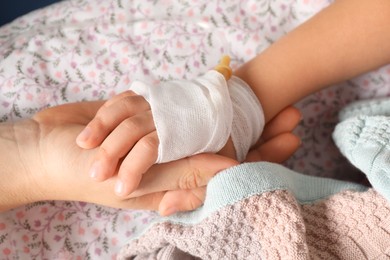 Photo of Doctor and child with intravenous drip at hospital, closeup