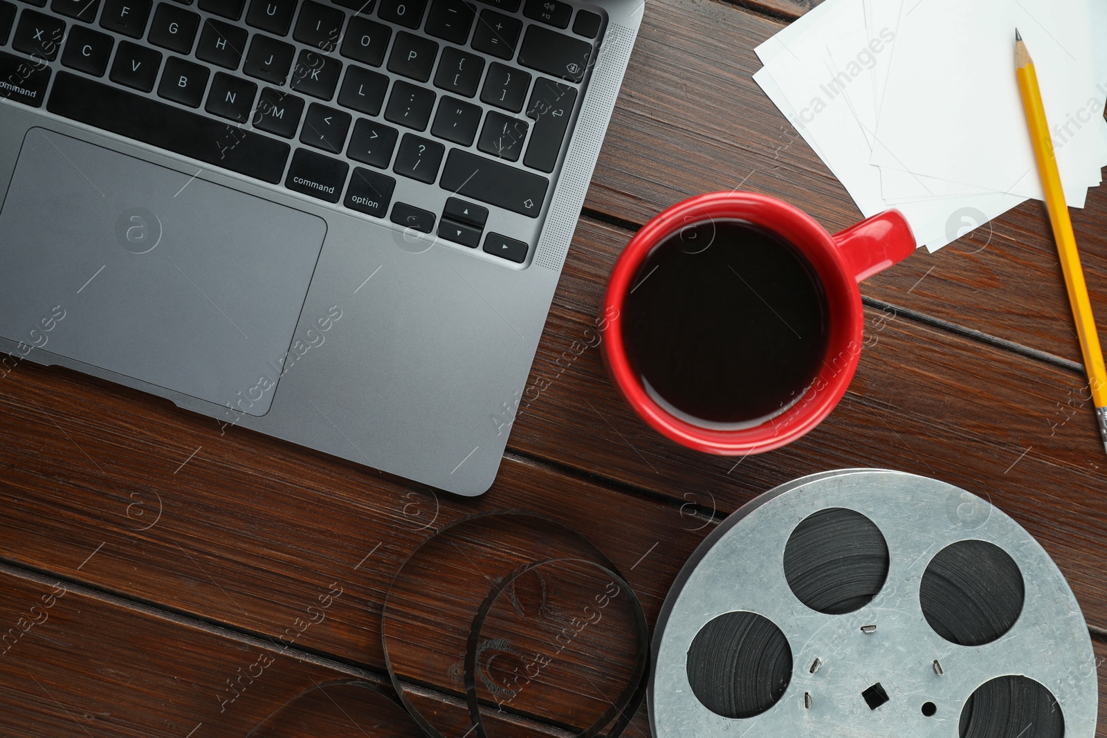 Photo of Flat lay composition with film reel and laptop on wooden table