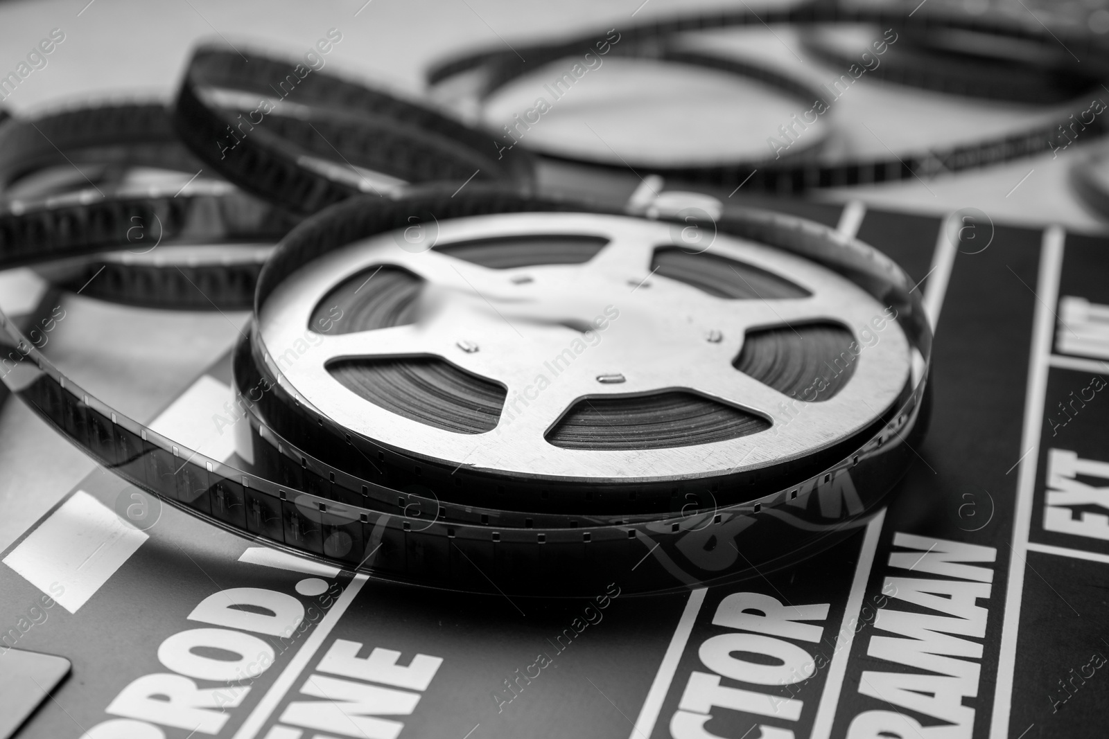 Photo of Movie clapper and film reel on table, closeup