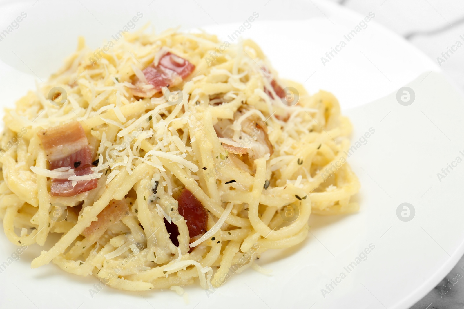 Photo of Delicious pasta Carbonara with bacon on plate, closeup