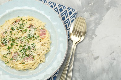 Photo of Delicious pasta Carbonara with bacon served on gray textured table, flat lay