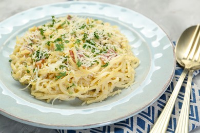 Photo of Delicious pasta Carbonara with bacon served on gray table, closeup