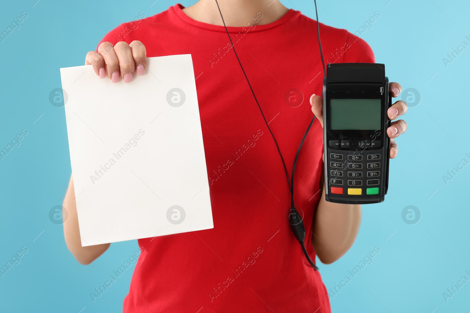 Photo of Fast-food worker with paper bag and payment terminal on light blue background, closeup