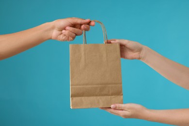 Photo of Fast-food worker giving customer's order on light blue background, closeup