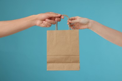 Fast-food worker giving customer's order on light blue background, closeup