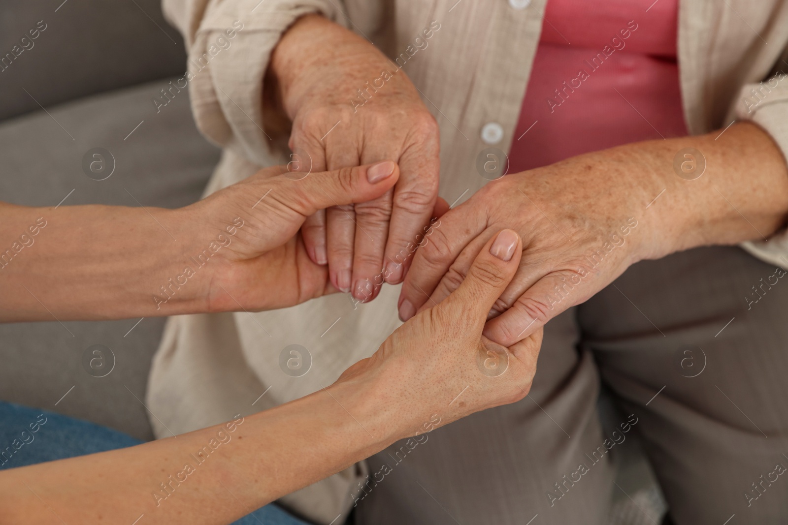 Photo of Caregiver supporting senior woman at home, closeup