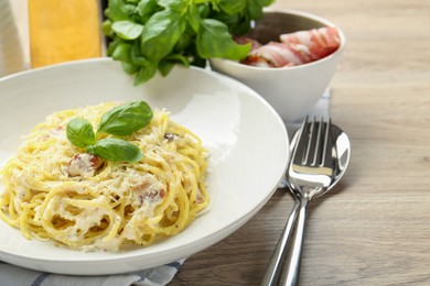 Photo of Delicious pasta Carbonara served on wooden table, closeup