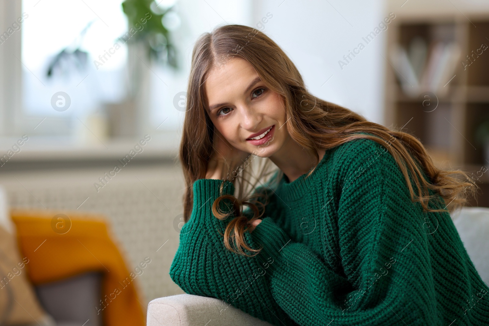 Photo of Charming young woman on sofa at home. Autumn atmosphere