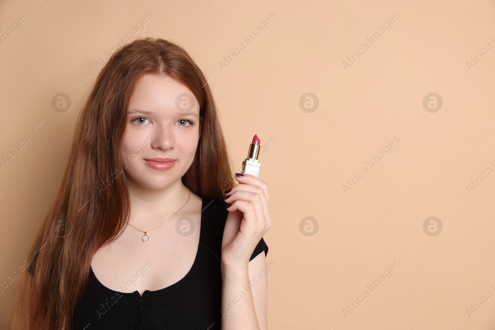 Photo of Teenage girl with lipstick on beige background. Space for text