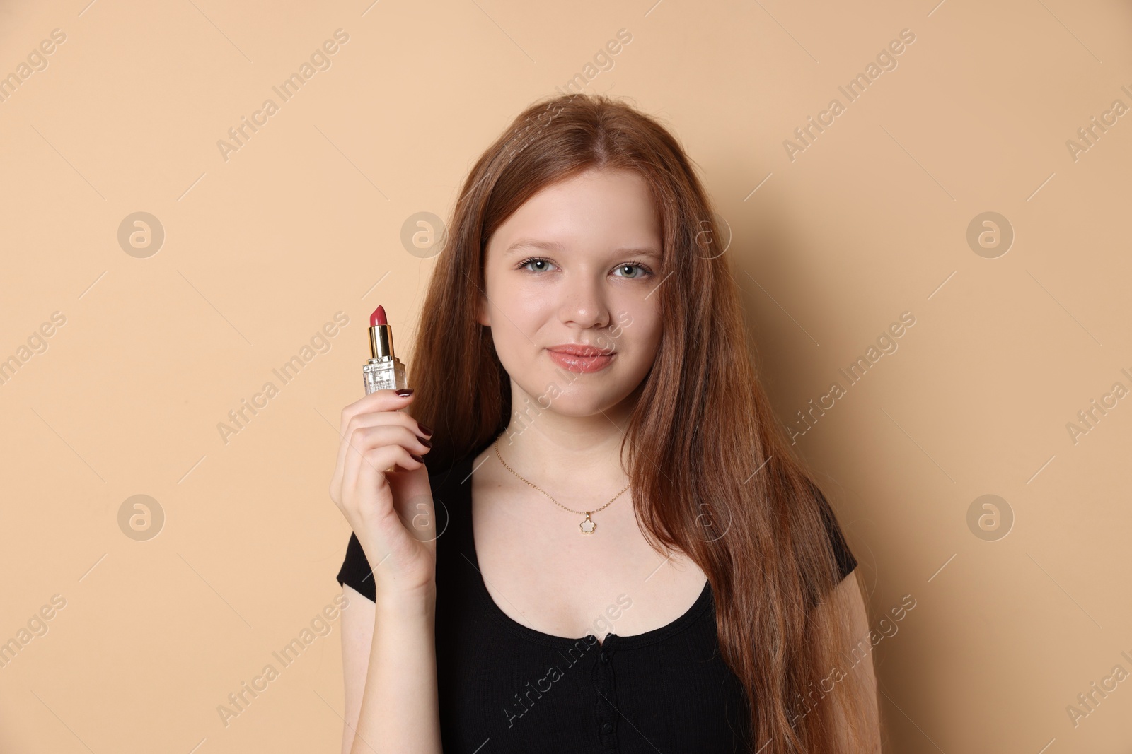 Photo of Teenage girl with lipstick on beige background