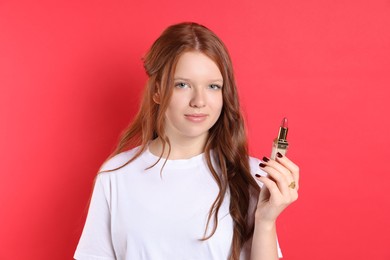 Teenage girl with lipstick on red background