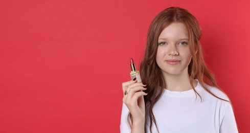 Photo of Teenage girl with lipstick on red background. Space for text