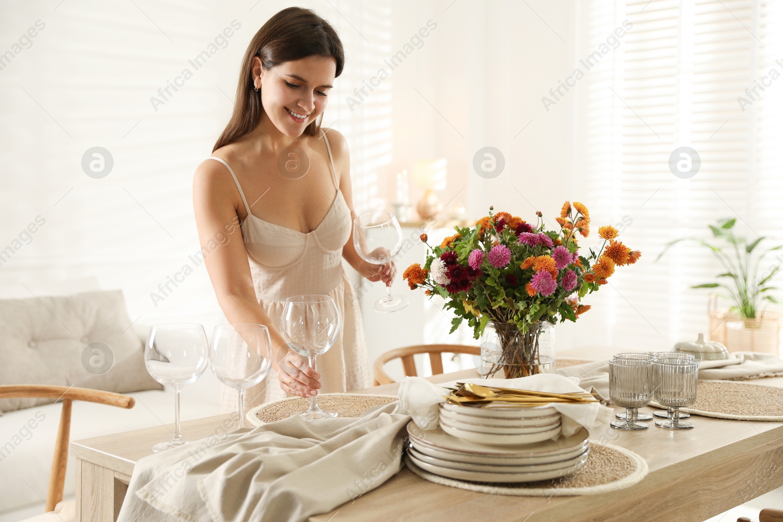 Photo of Woman setting table for dinner at home