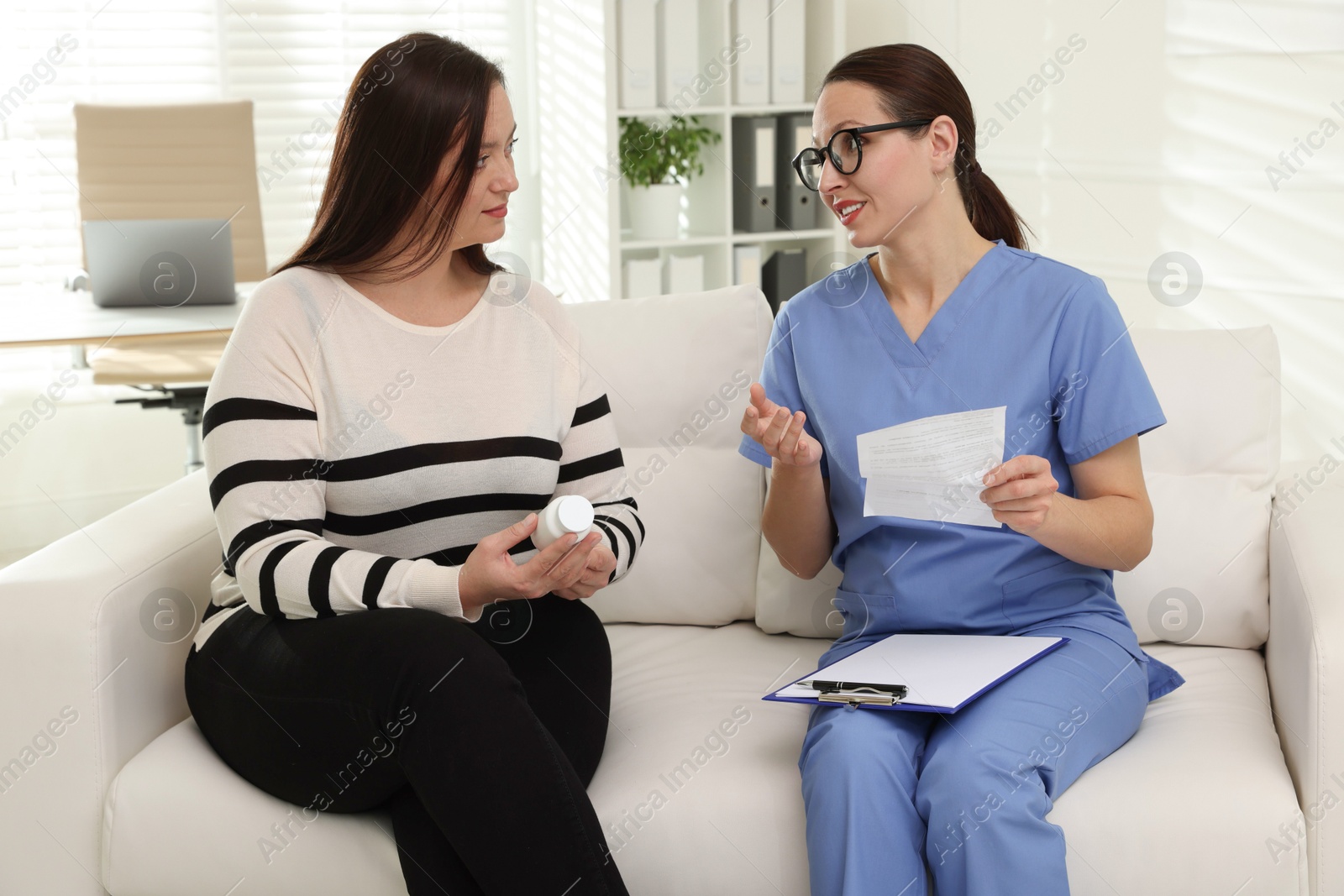 Photo of Nutritionist giving recommendations to overweight woman on couch in hospital