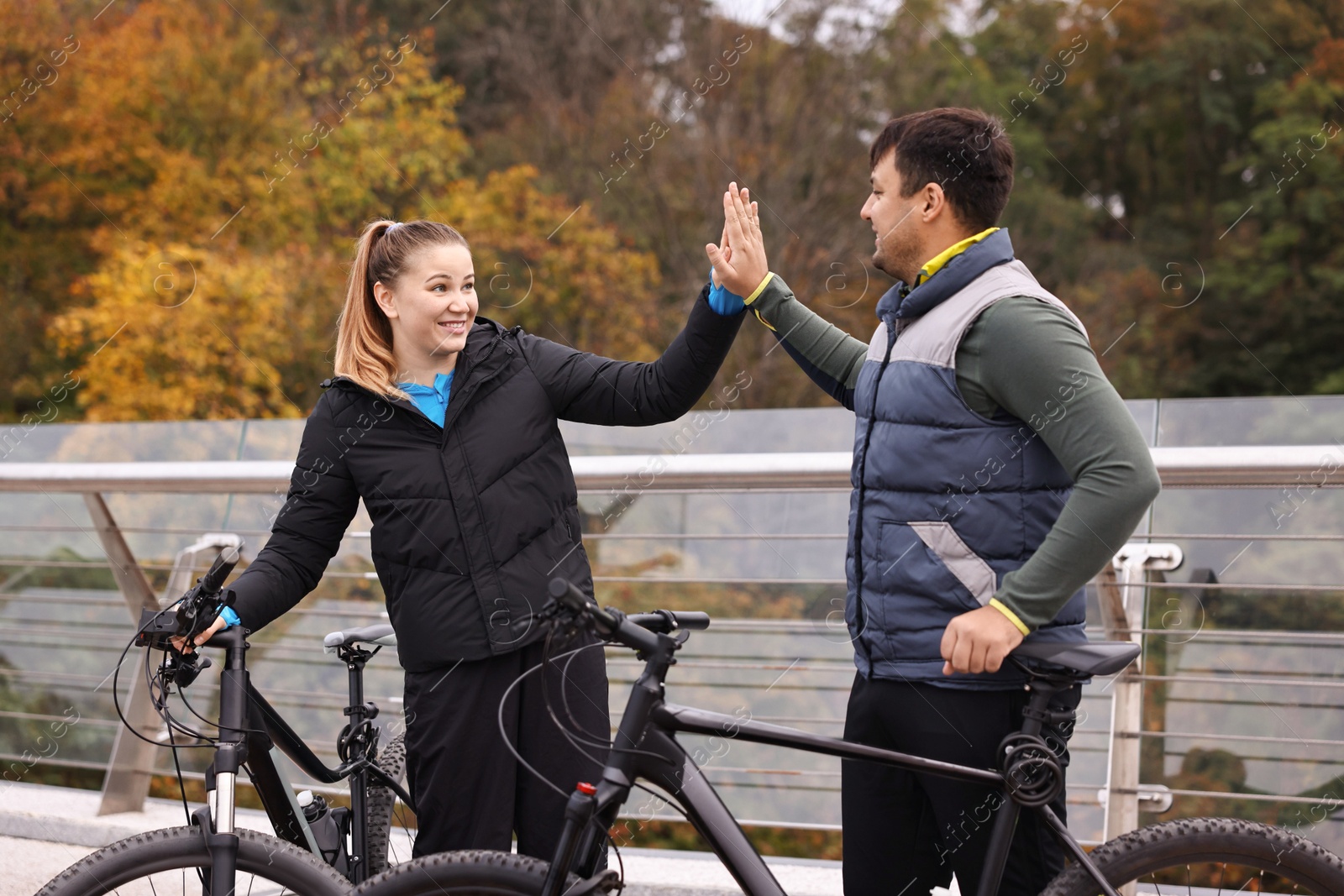 Photo of Beautiful happy couple with bicycles spending time together outdoors