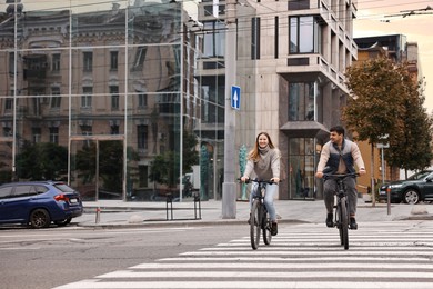 Photo of Beautiful happy couple riding bicycles and spending time together outdoors, space for text