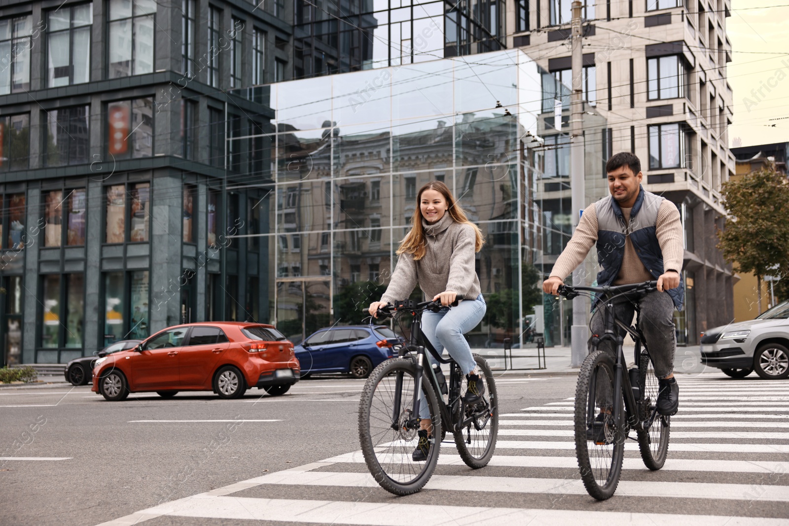 Photo of Beautiful happy couple riding bicycles and spending time together outdoors, space for text