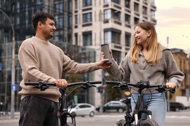 Photo of Beautiful happy couple with bicycles spending time together outdoors