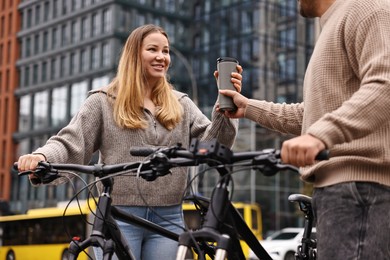 Photo of Beautiful happy couple with bicycles spending time together outdoors