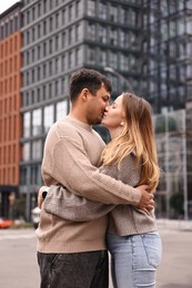 Photo of Beautiful happy couple kissing on city street