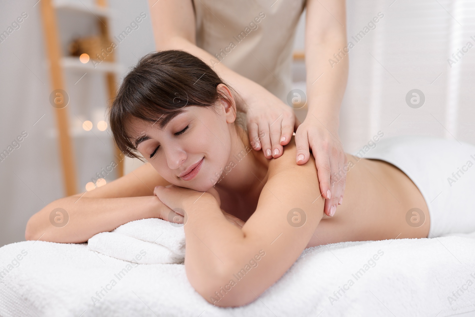 Photo of Young woman receiving massage in spa salon