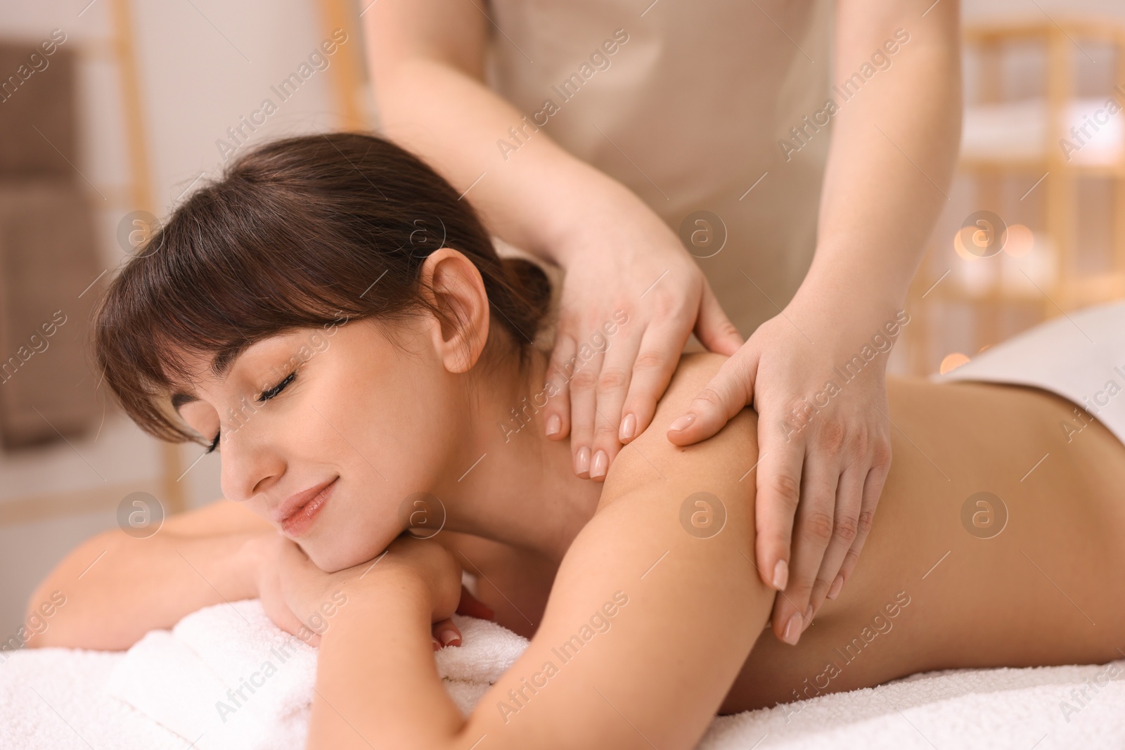 Photo of Young woman receiving massage in spa salon