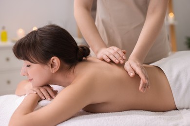 Young woman receiving back massage in spa salon