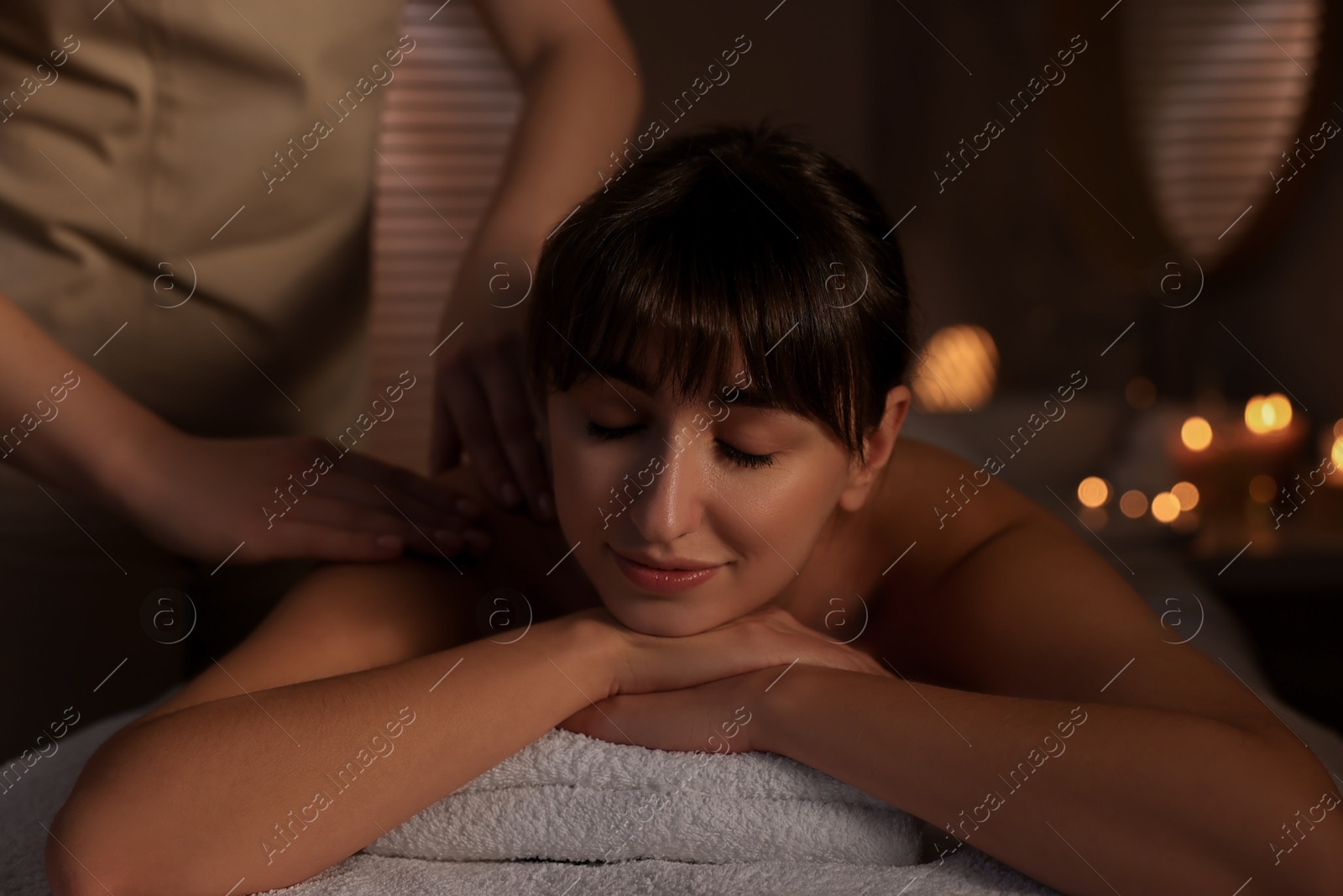 Photo of Young woman receiving massage in spa salon