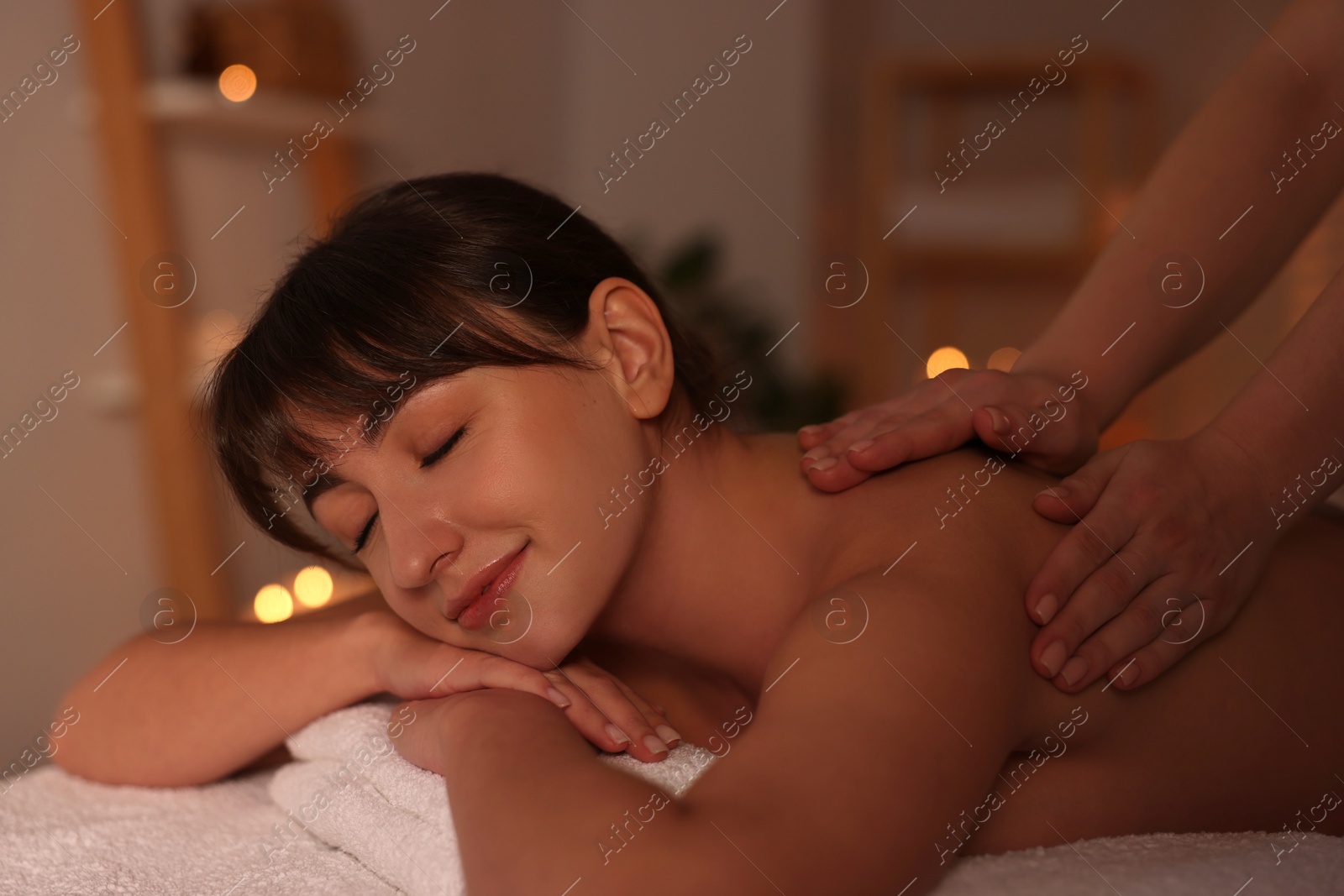 Photo of Young woman receiving massage in spa salon