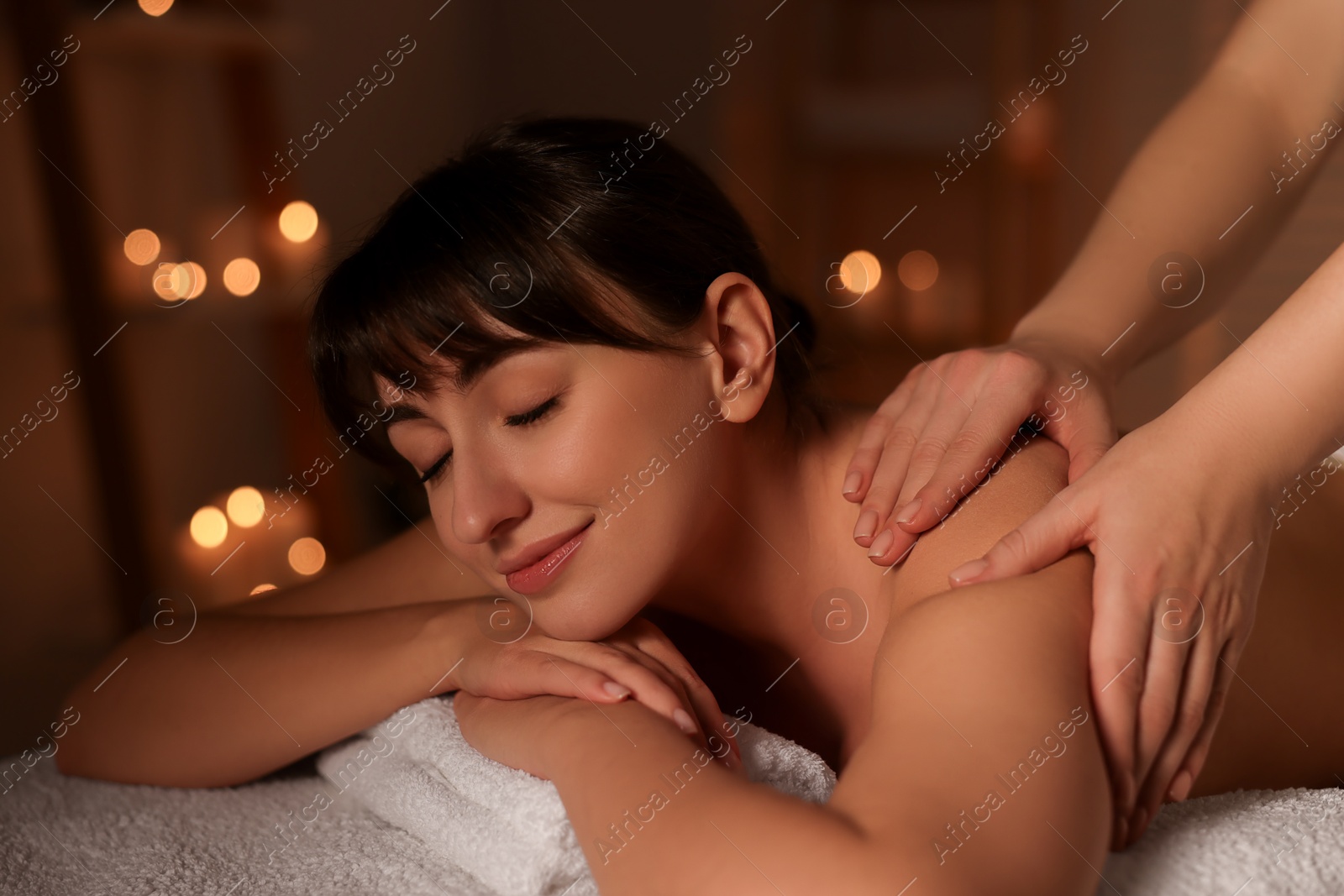 Photo of Young woman receiving massage in spa salon