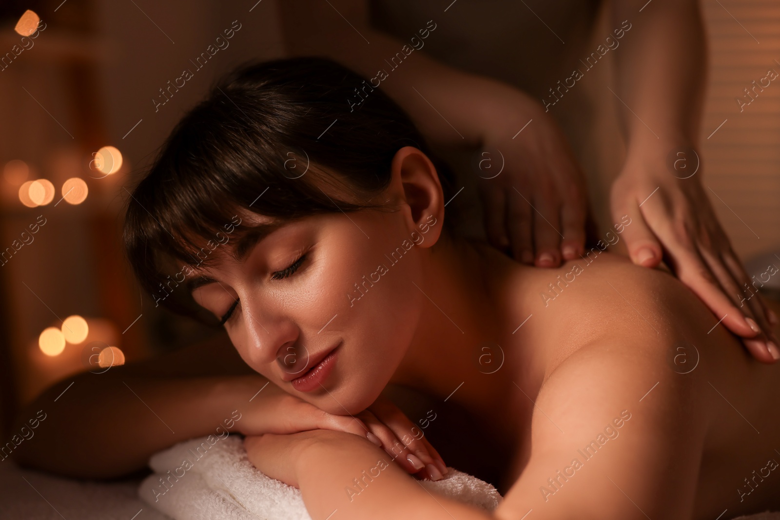 Photo of Young woman receiving massage in spa salon