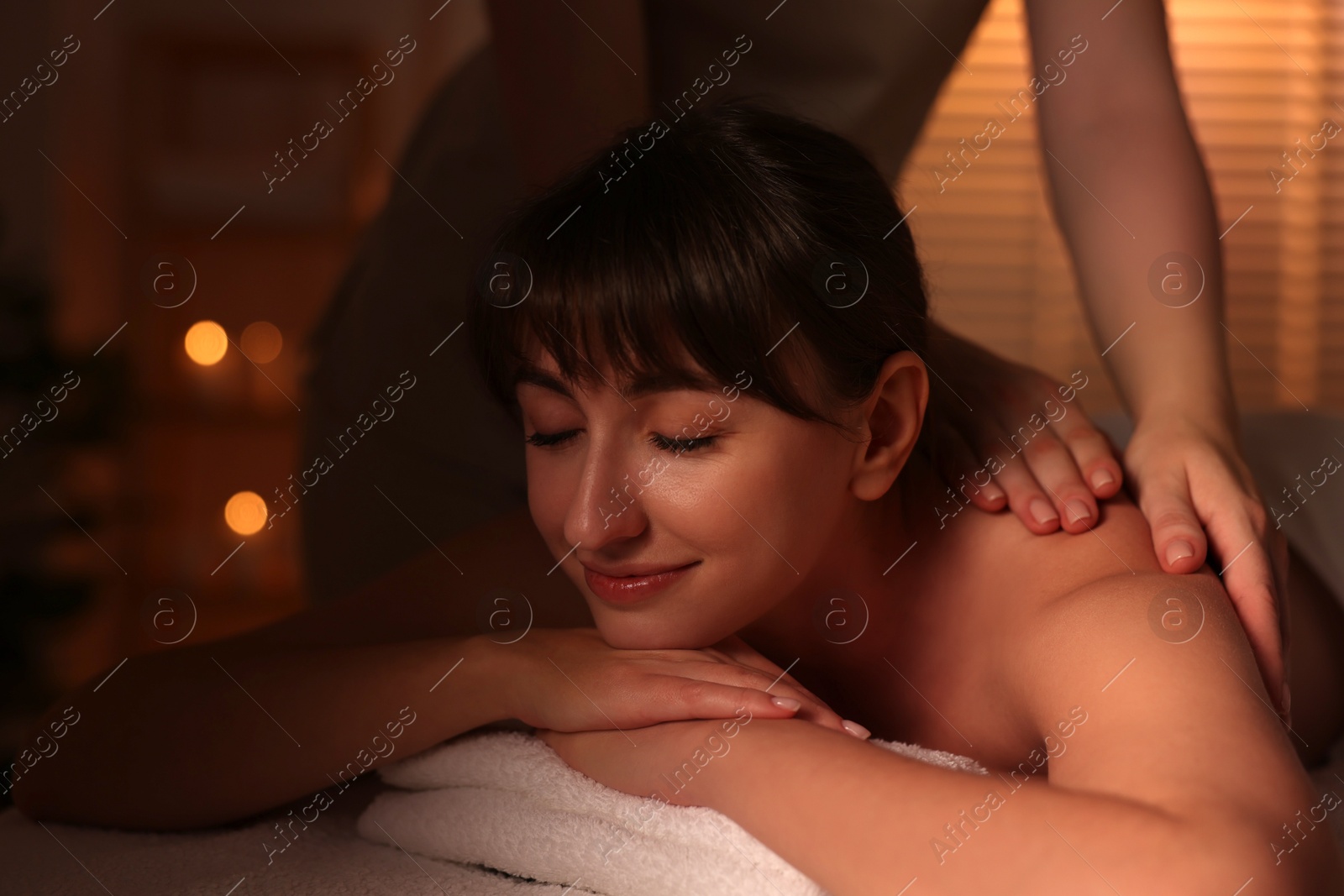 Photo of Young woman receiving massage in spa salon