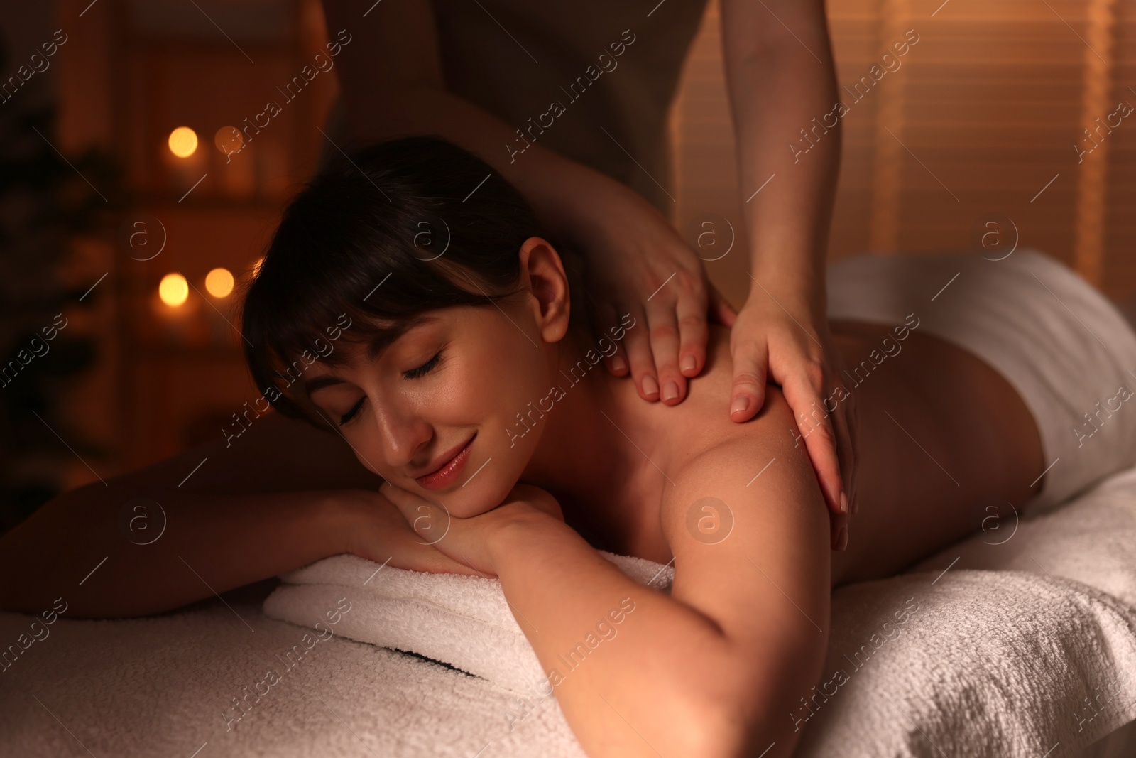 Photo of Young woman receiving massage in spa salon