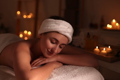 Photo of Young woman relaxing after massage in spa salon