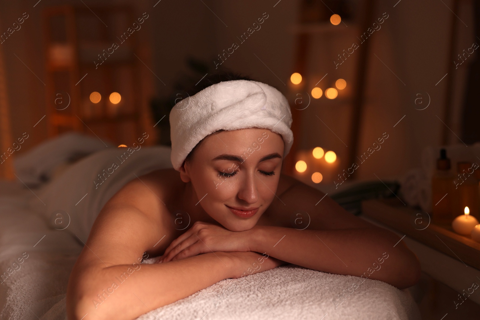 Photo of Young woman relaxing after massage in spa salon