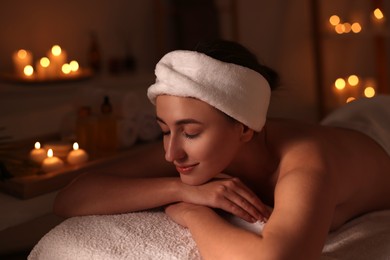 Photo of Young woman relaxing after massage in spa salon