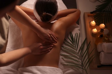 Woman receiving massage in spa salon, back view