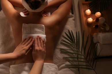 Photo of Woman receiving back massage in spa salon, top view