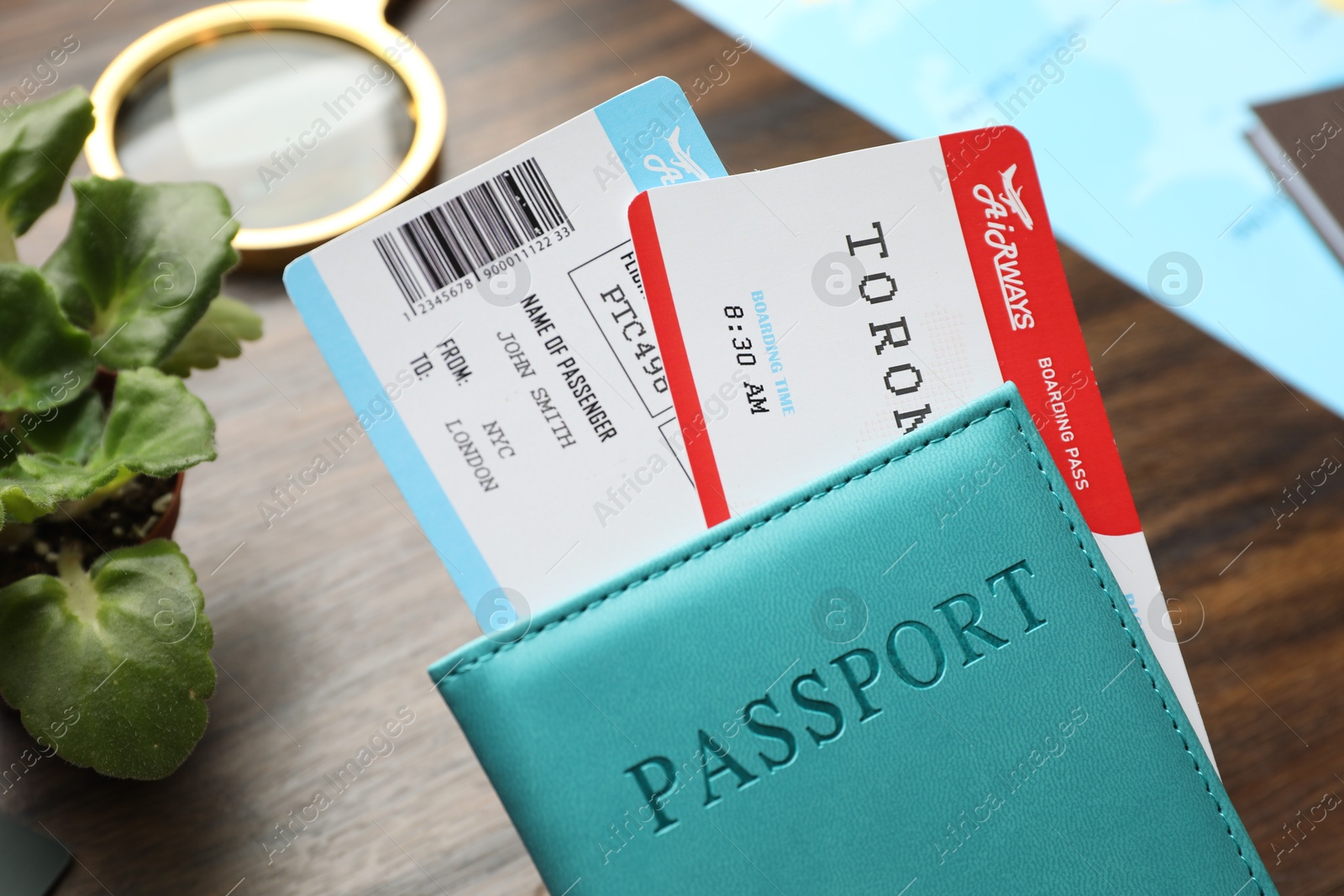 Photo of Travel agency. Passport with flight tickets at wooden table, closeup