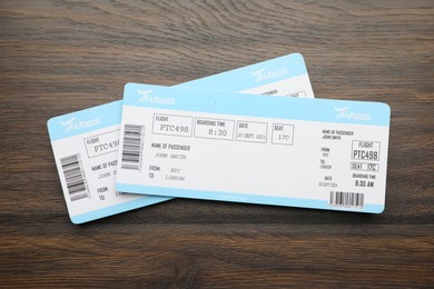 Photo of Travel agency. Flight tickets on wooden table, top view